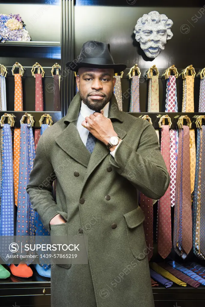 Cool male customer wearing trilby in tailors shop, portrait