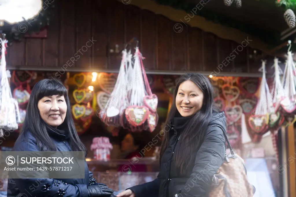 Mother and daughter window shopping at Christmas market, Freiburg, Baden-Wurttemberg, Germany