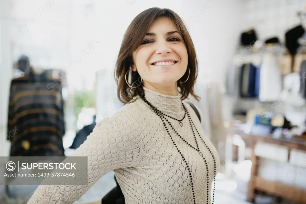 Woman showing off necklace in fashion boutique