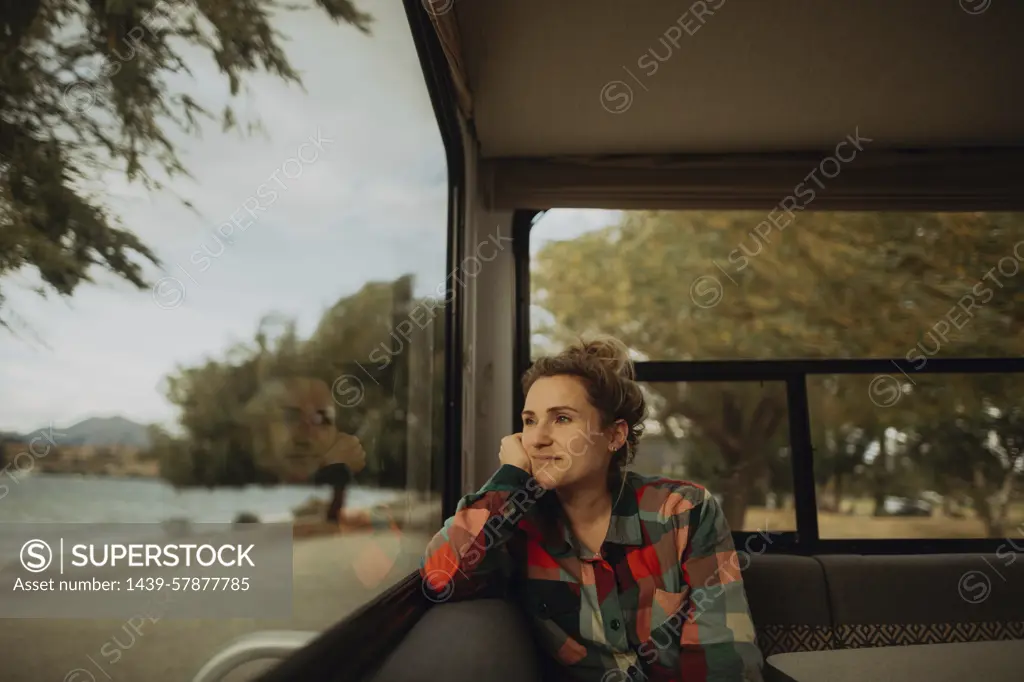 Woman looking out window of motorhome, Wanaka, Taranaki, New Zealand