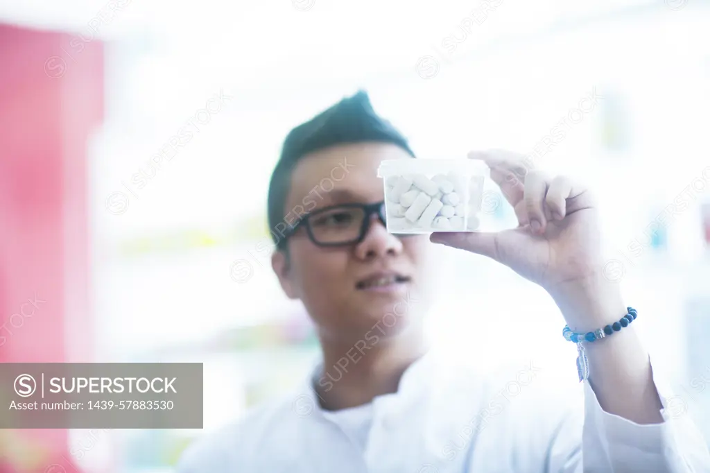 Young pharmacist showcasing a medicine package