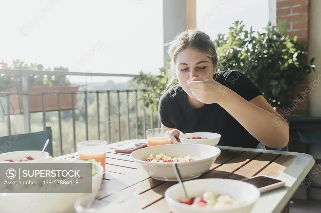 Woman enjoying a healthy breakfast on a sunny terrace