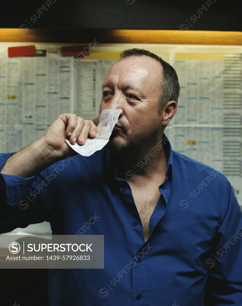 Man smelling a twenty pound note