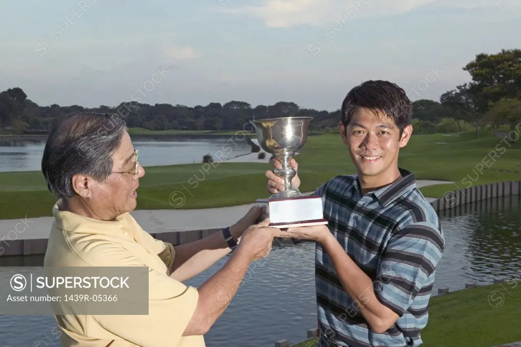 Father and son holding trophy