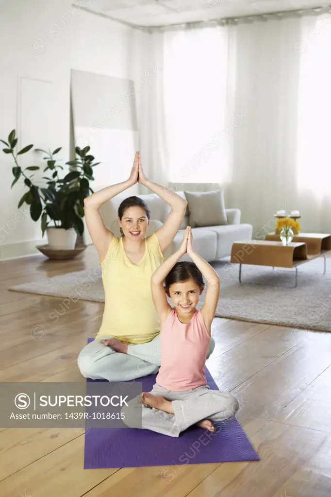 Mother and daughter practising yoga