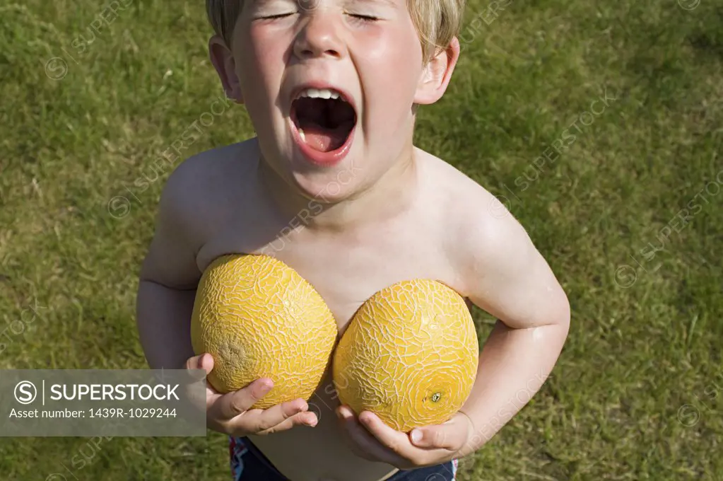 Boy holding melon halves