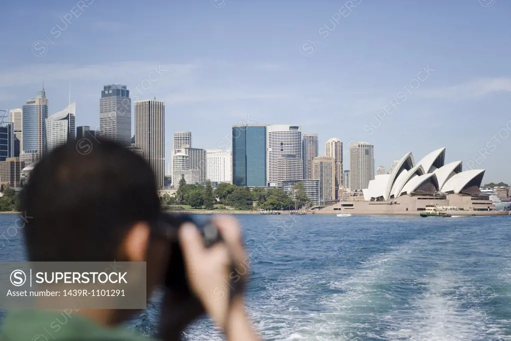 A tourist photographing sydney opera house