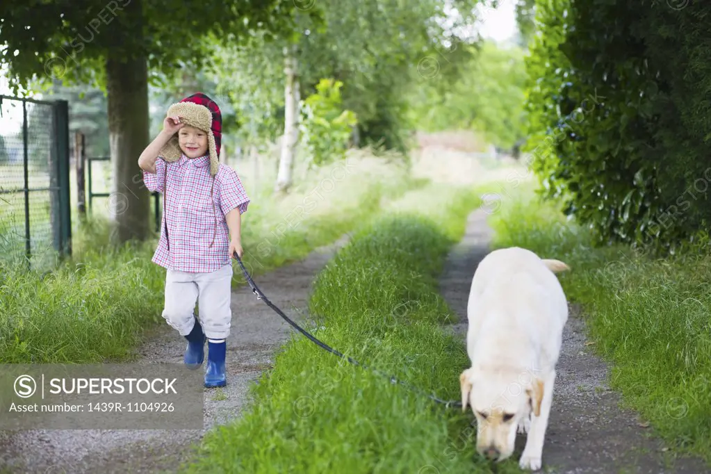 A boy walking his dog