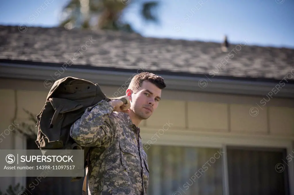 Portrait of intense looking male soldier in garden on homecoming