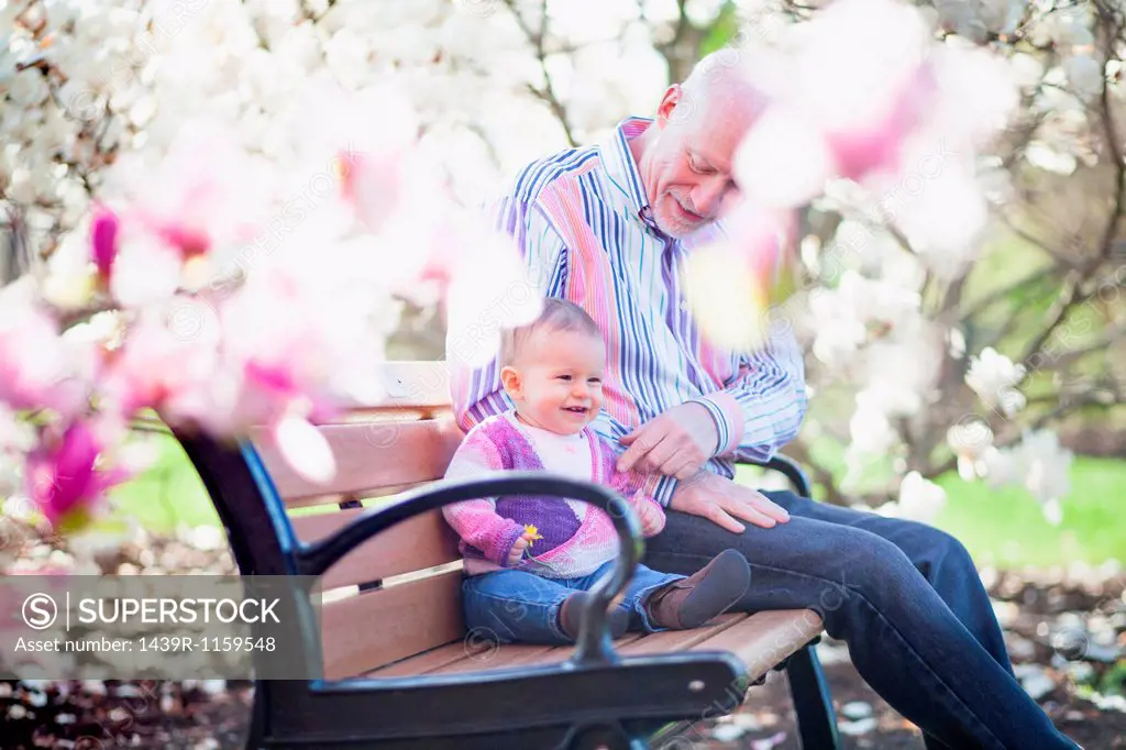 Grandfather and granddaughter together in park