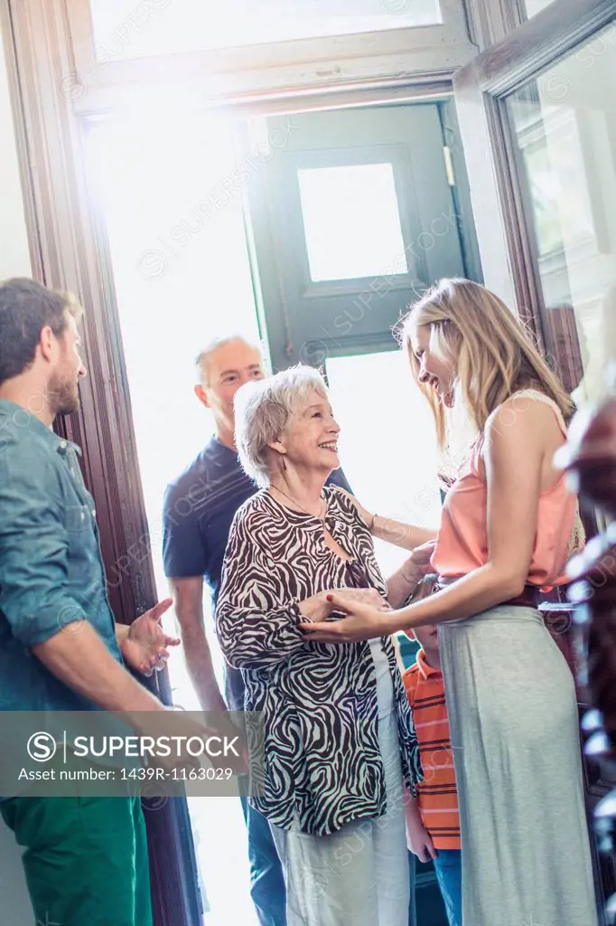 Woman greeting parents in hallway