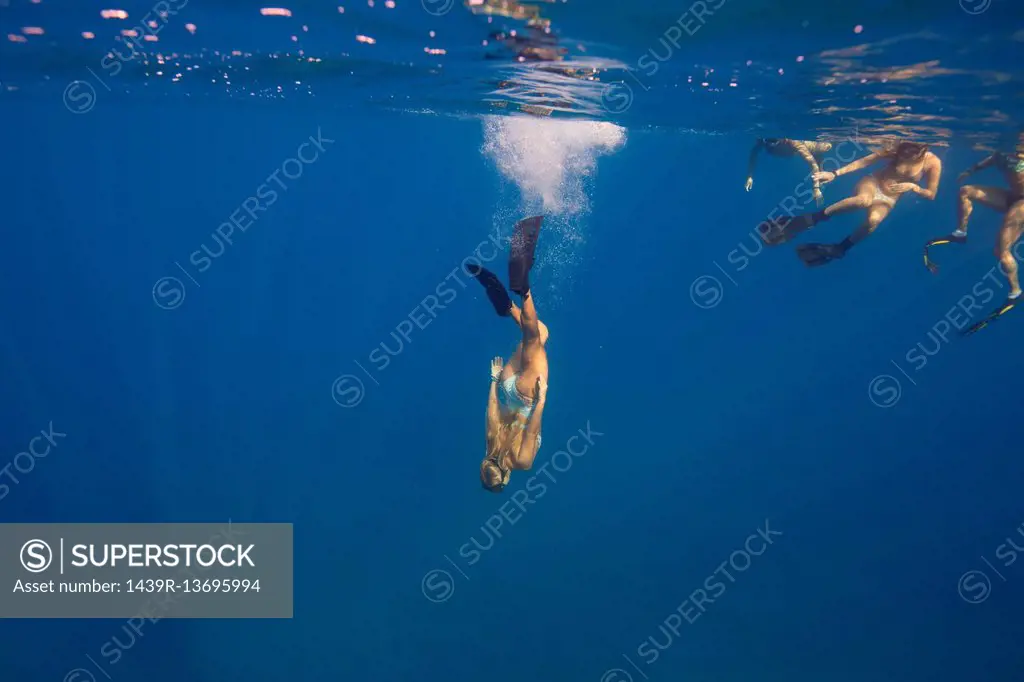 Women wearing flippers swimming underwater, Oahu, Hawaii, USA