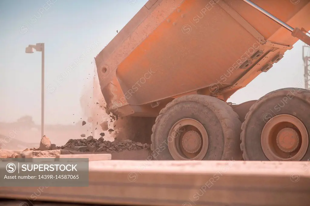 Dump truck in quarry, tipping load of stones