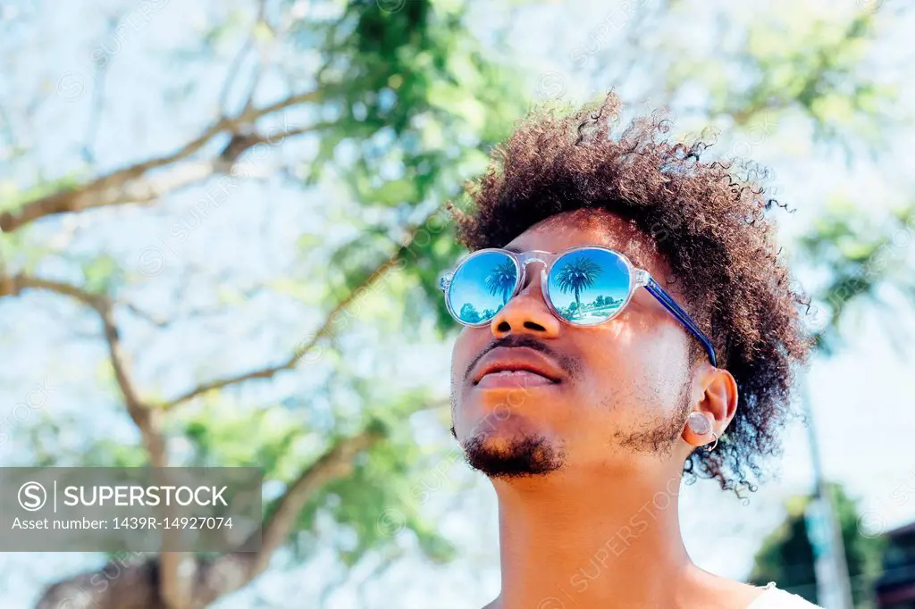 Man wearing sunglasses, looking up