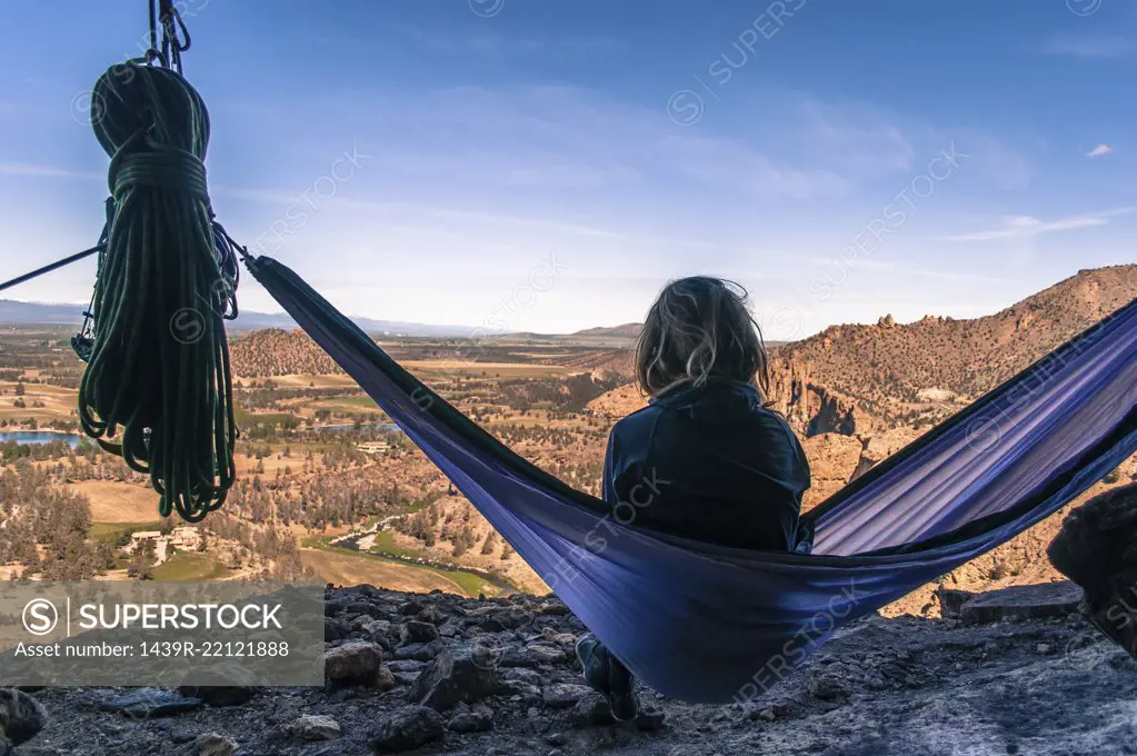 Rock climber on hammock on summit, Smith Rock State Park, Oregon, USA