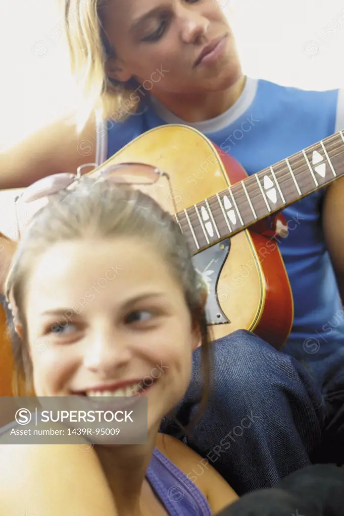 Teenage boy and girl playing the guitar