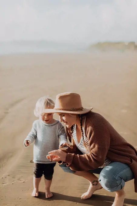 Mother and toddler playing on beach