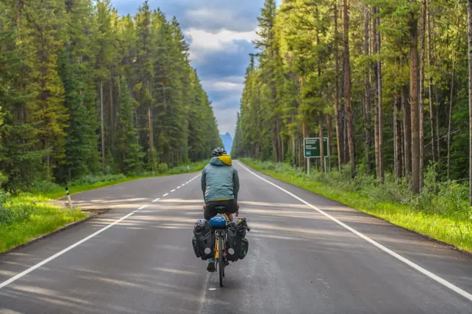 Man cycling on road, Banff National Park, Alberta, Canada