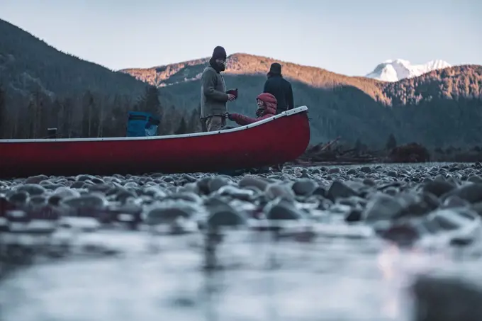 Canada, British Columbia, Friends with canoe resting at Squamish River