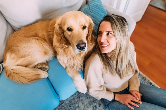 Italy, Young woman with dog at home