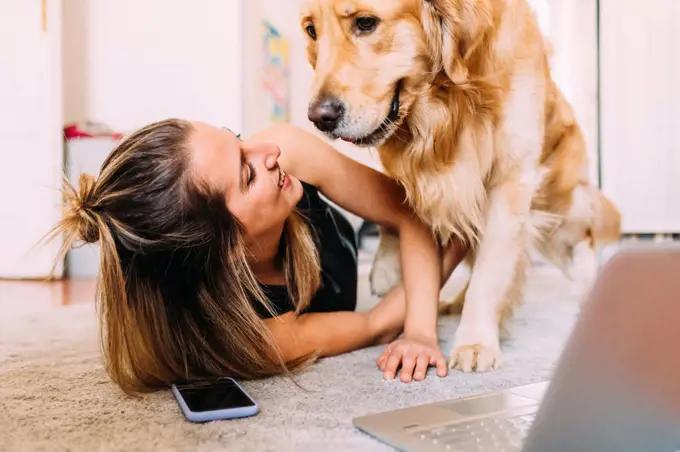 Italy, Young woman with dog at home