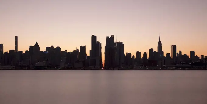 USA, NY, New York City, Midtown Manhattan seen across river at sunset