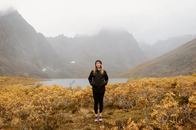Canada, Yukon, Whitehorse, Portrait of woman standing in mountain landscape