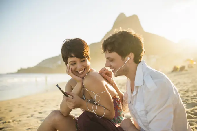 Young couple listening to music, Ipanema Beach, Rio, Brazil