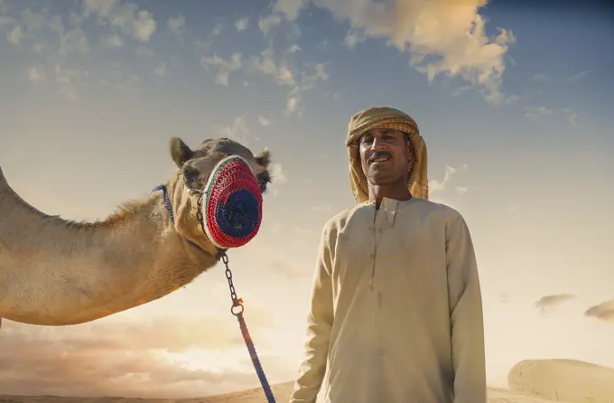 Portrait of camel and bedouin in desert, Dubai, United Arab Emirates