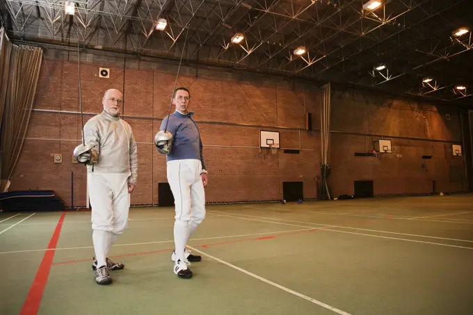 Two fencers take a break during practice.