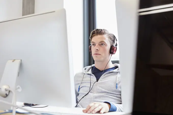 Young male computer aided designer working on computer in design studio