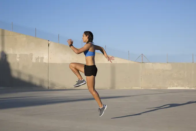 Female athlete doing high knees exercise, Van Nuys, California, USA