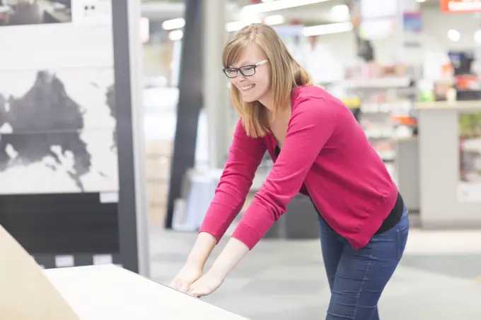 Female customer opening chest of drawers in hardware store