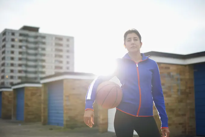 Portrait of mature female basketball player holding ball