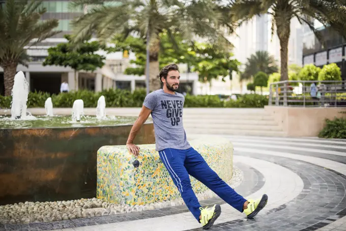 Man training, doing warm ups in park, Dubai, United Arab Emirates