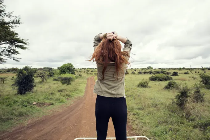 Woman enjoying ride on top of vehicle in wildlife park, Nairobi, Kenya