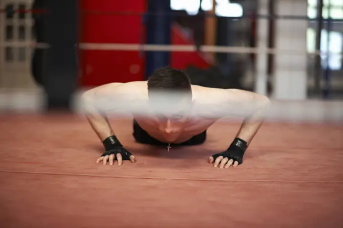 Boxer doing push-ups in boxing ring