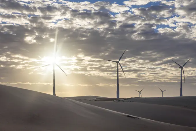 Wind turbines in desert landscape at sunset, Taiba, Ceara, Brazil