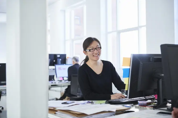 Woman working in office, using computer