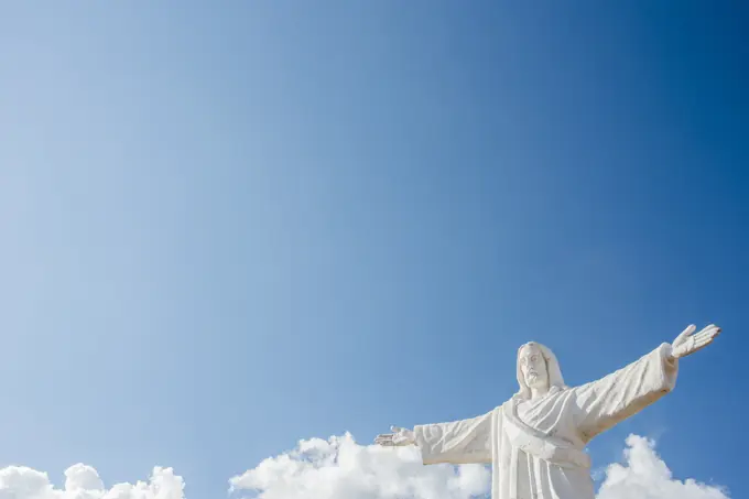 Statue of Christ against blue sky at Sacsayhuaman in Cusco, Peru