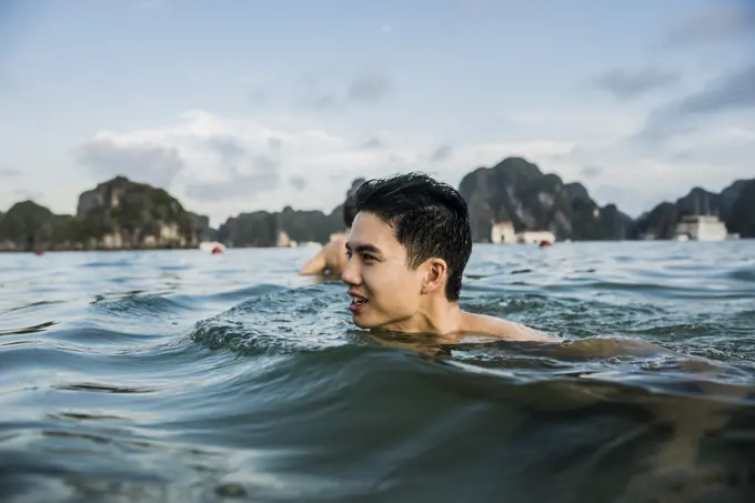 Man swimming in waters of Ha Long Bay, Vietnam