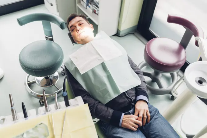 Male patient in dentist chair, elevated view