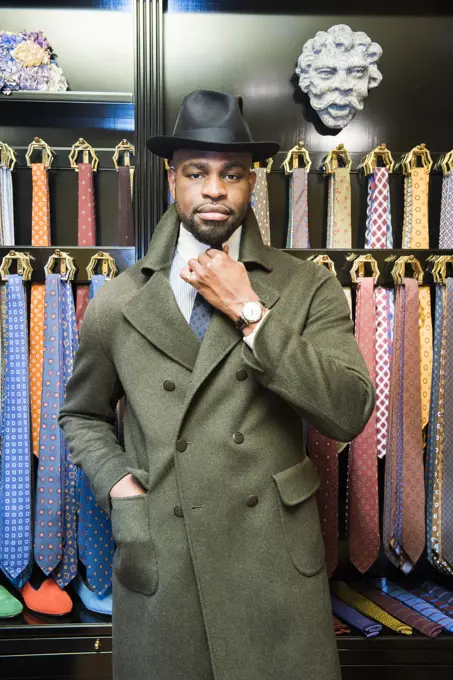 Cool male customer wearing trilby in tailors shop, portrait