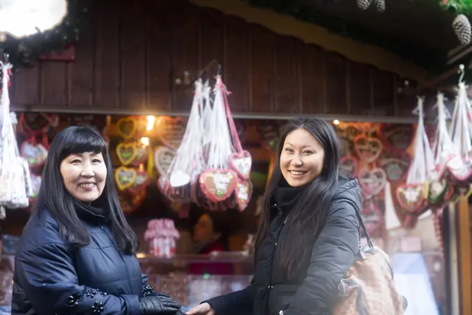 Mother and daughter window shopping at Christmas market, Freiburg, Baden-Wurttemberg, Germany