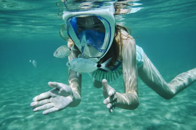 Underwater view of girl snorkelling, looking at fish, Limnos, Khios, Greece