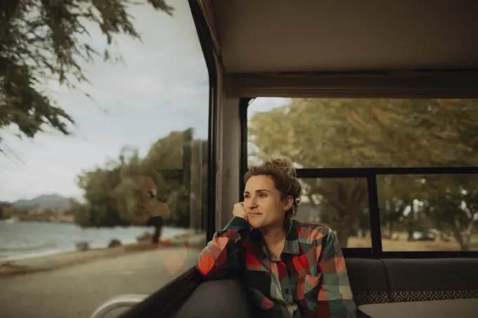 Woman looking out window of motorhome, Wanaka, Taranaki, New Zealand