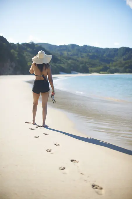 Woman on New Chums beach, Coromandel Peninsula, New Zealand