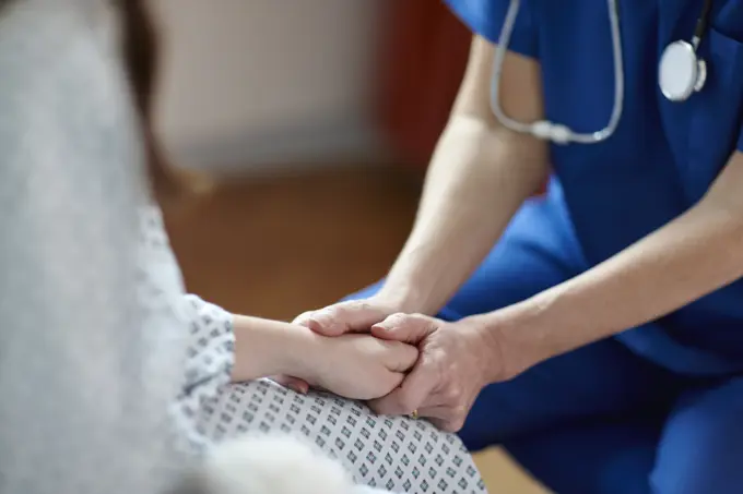 Cropped image of nurse holding patient's hand