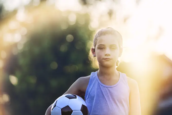 Young soccer player ready for the game at sunset