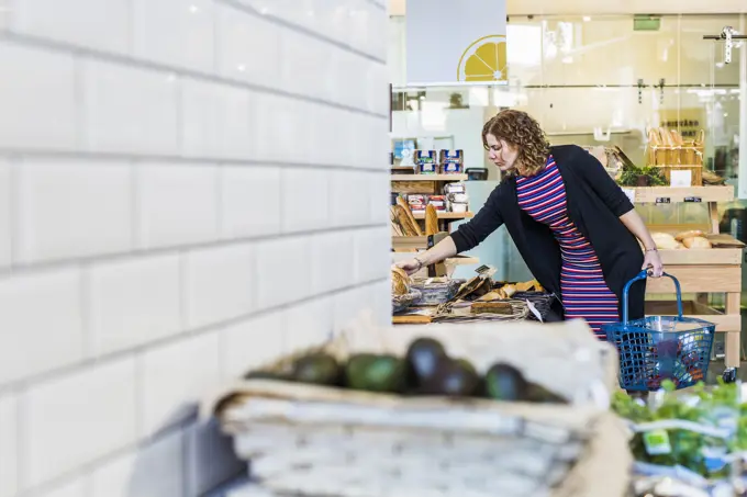 A woman shopping for groceries in a welllit store.